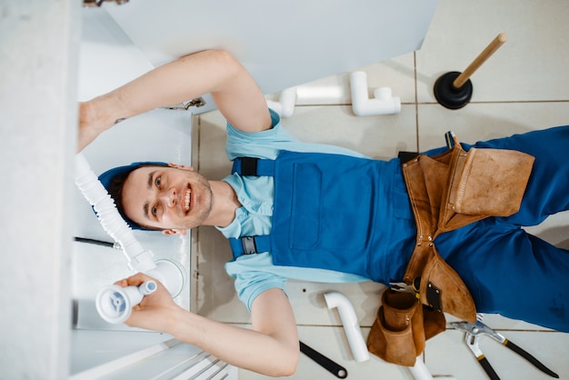 male plumber uniform installing drain pipe kitchen top view handywoman with toolbag repair sink sanitary equipment service home 266732 22726